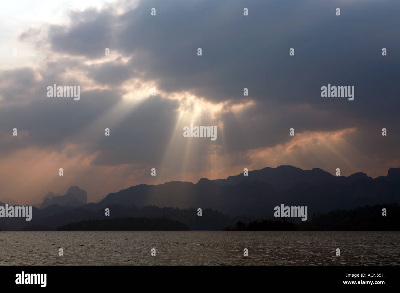 Des éclats de la lumière du soleil à travers les nuages au-dessus du lac Cheow lan, Parc national de Khao Sok Banque D'Images