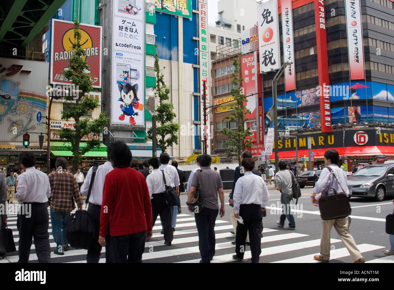 Les personnes qui traversent la rue dans l'électronique d'Akihabara district de Tokyo Japon avec de nombreux signes magasins publicité Banque D'Images