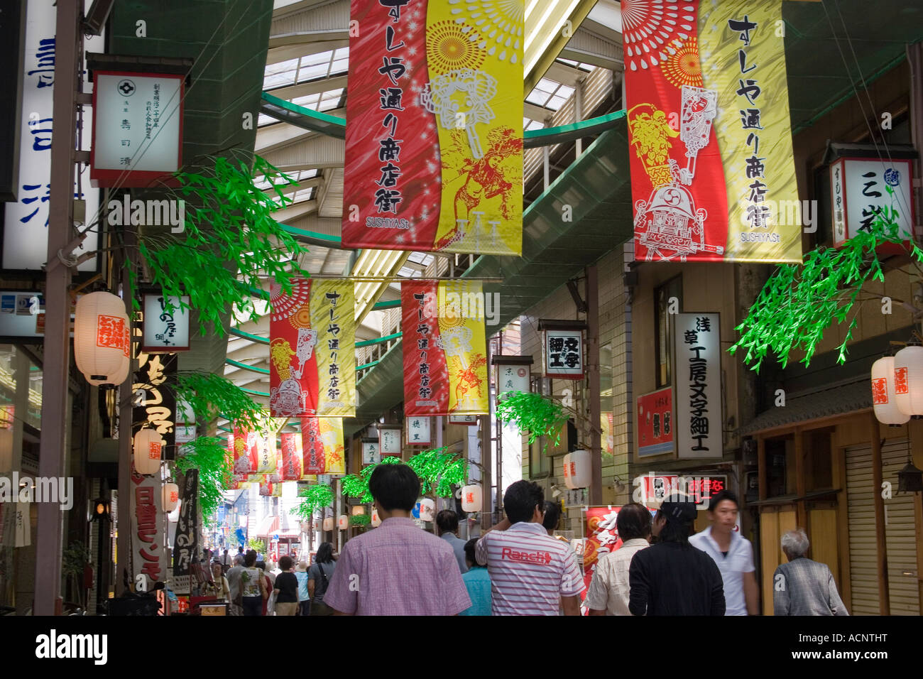 Les gens marcher dans un centre commercial avec des bannières colorées dans la zone touristique d'Asakusa Tokyo Japon Banque D'Images