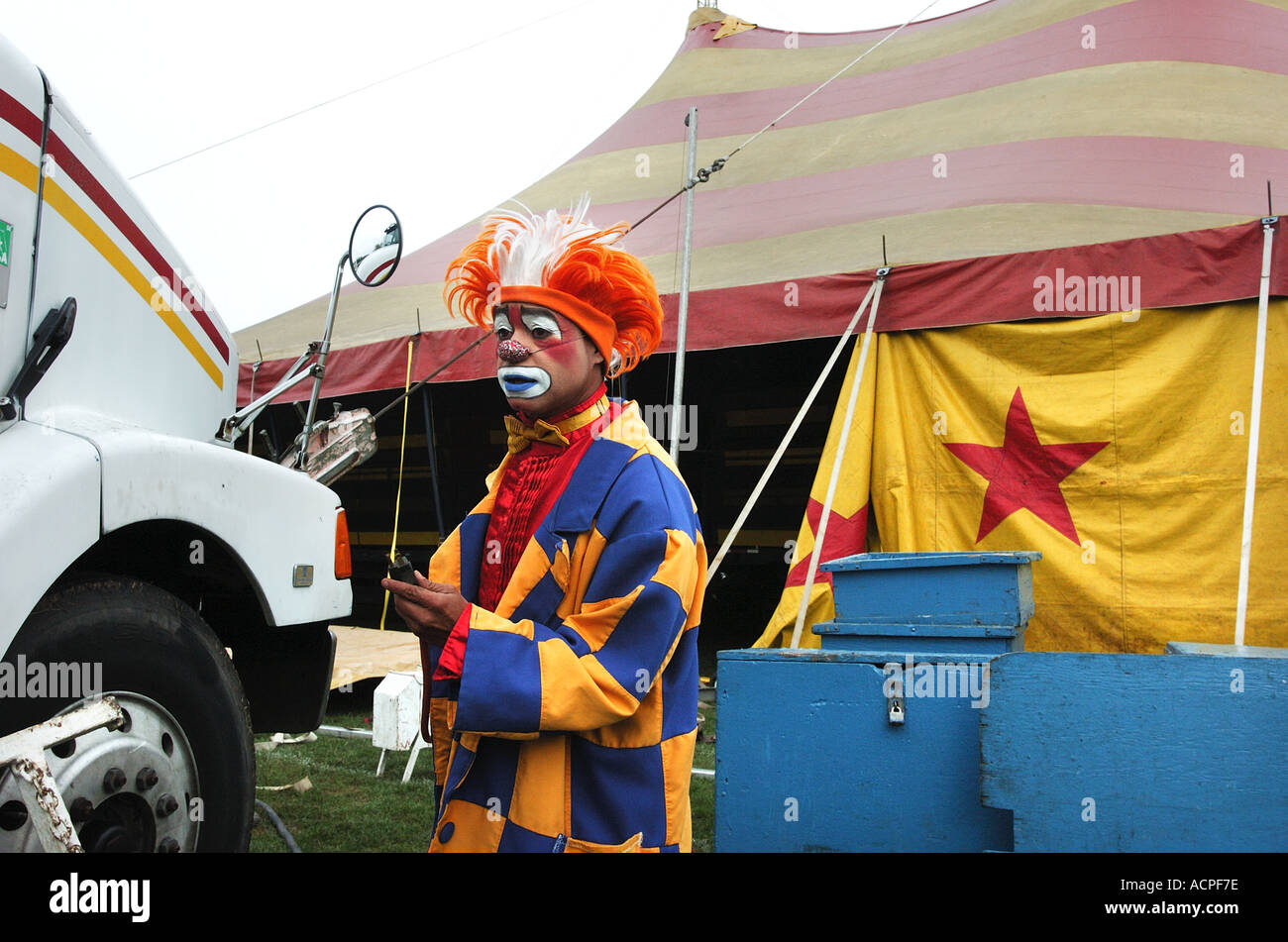 Un clown triste à la mise en place d'un chapiteau tente travaillant dans un cirque itinérant Banque D'Images