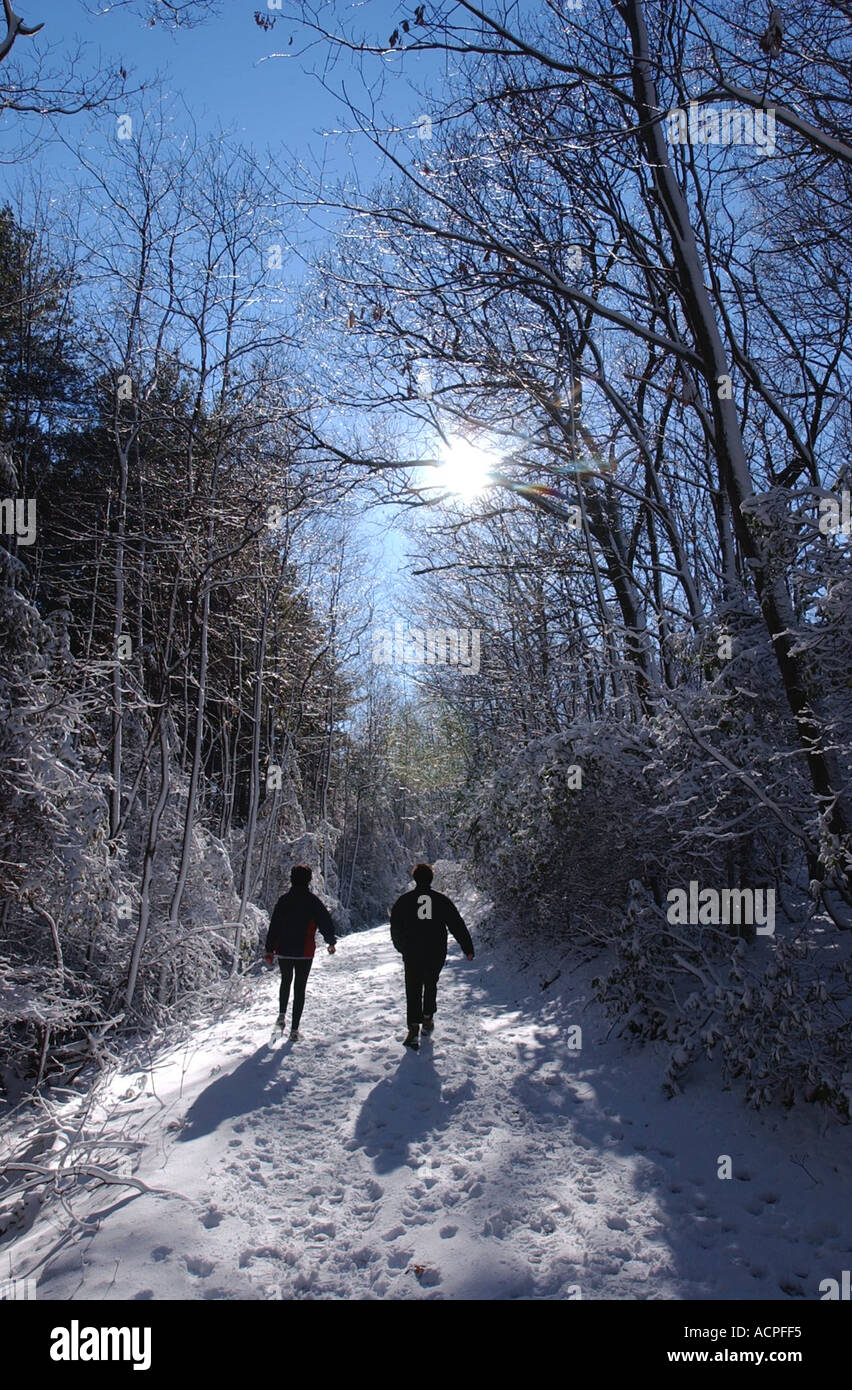 Deux femmes de la randonnée sur un sentier de neige avec soleil et ombre Banque D'Images