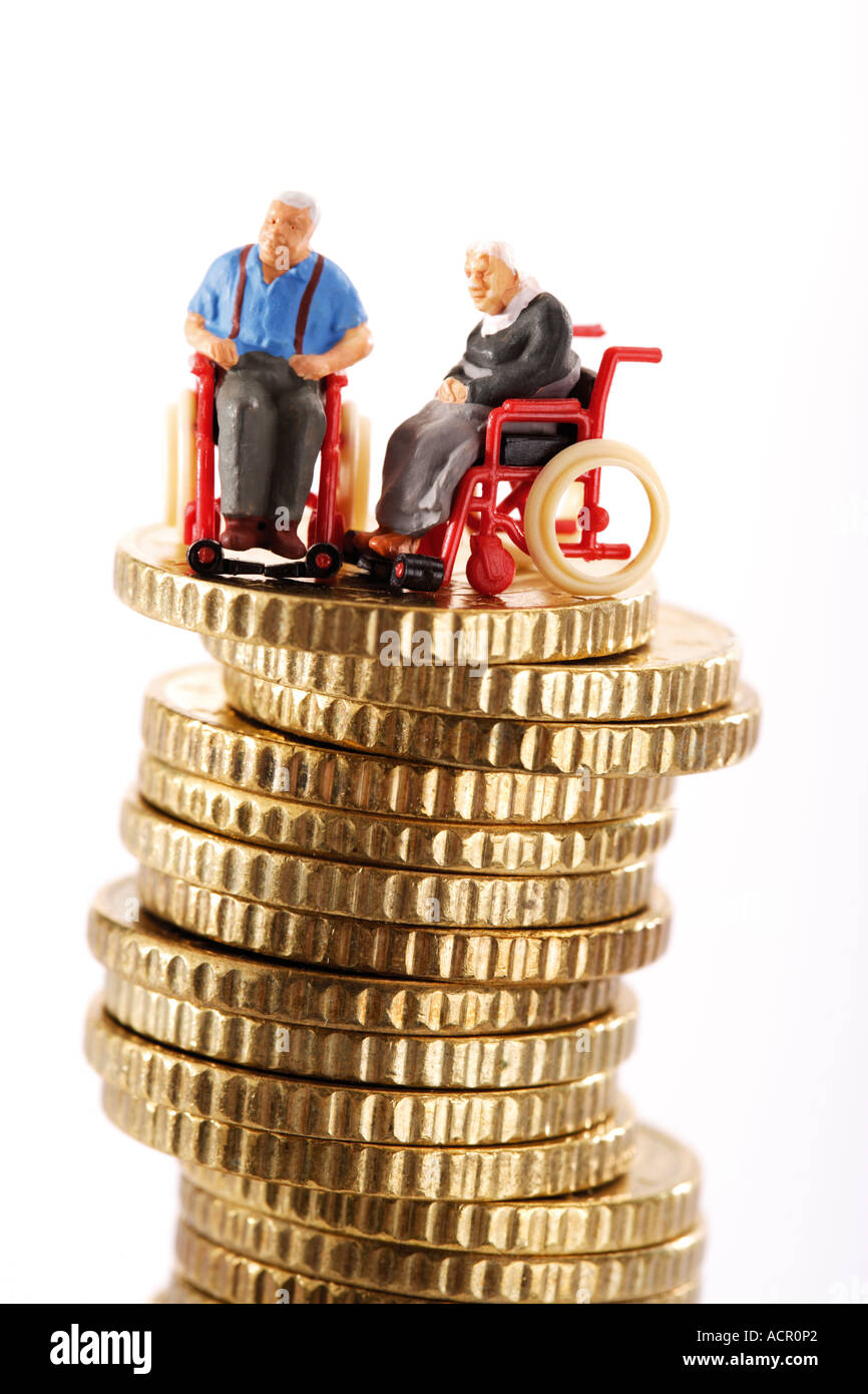Univers miniatures en fauteuil roulant sur la pile de pièces de monnaie Banque D'Images