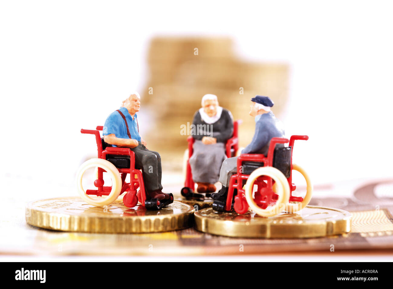 Univers miniatures en fauteuil roulant sur les pièces Banque D'Images