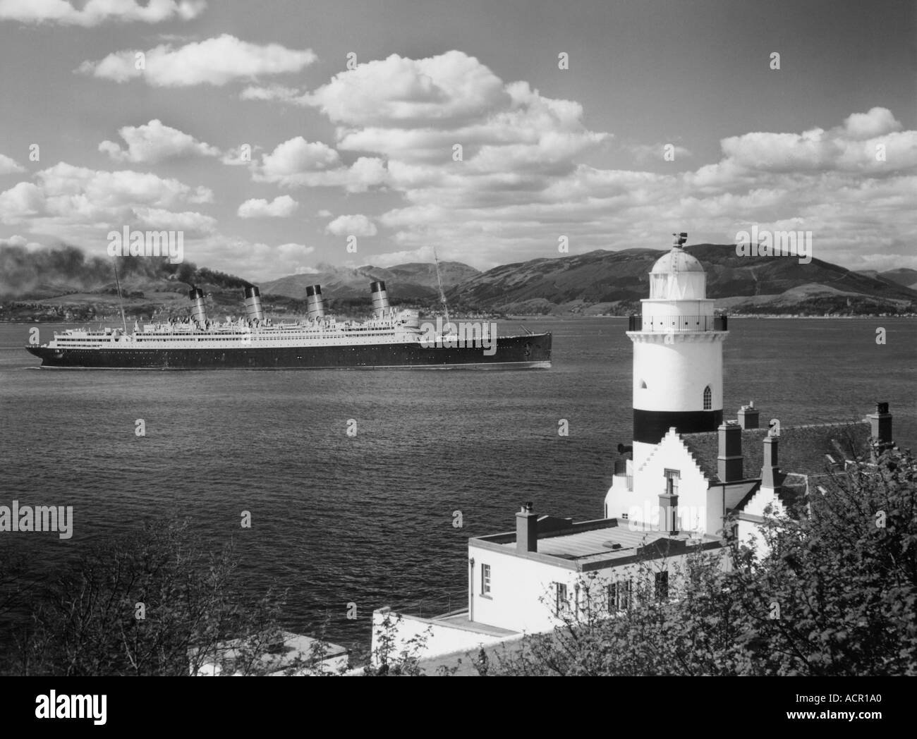 UK Ecosse Firth of Clyde l'horloge phare et SS Aquitania en 1950 pour être mis au rebut dans le Gareloch construit en 1914 Banque D'Images