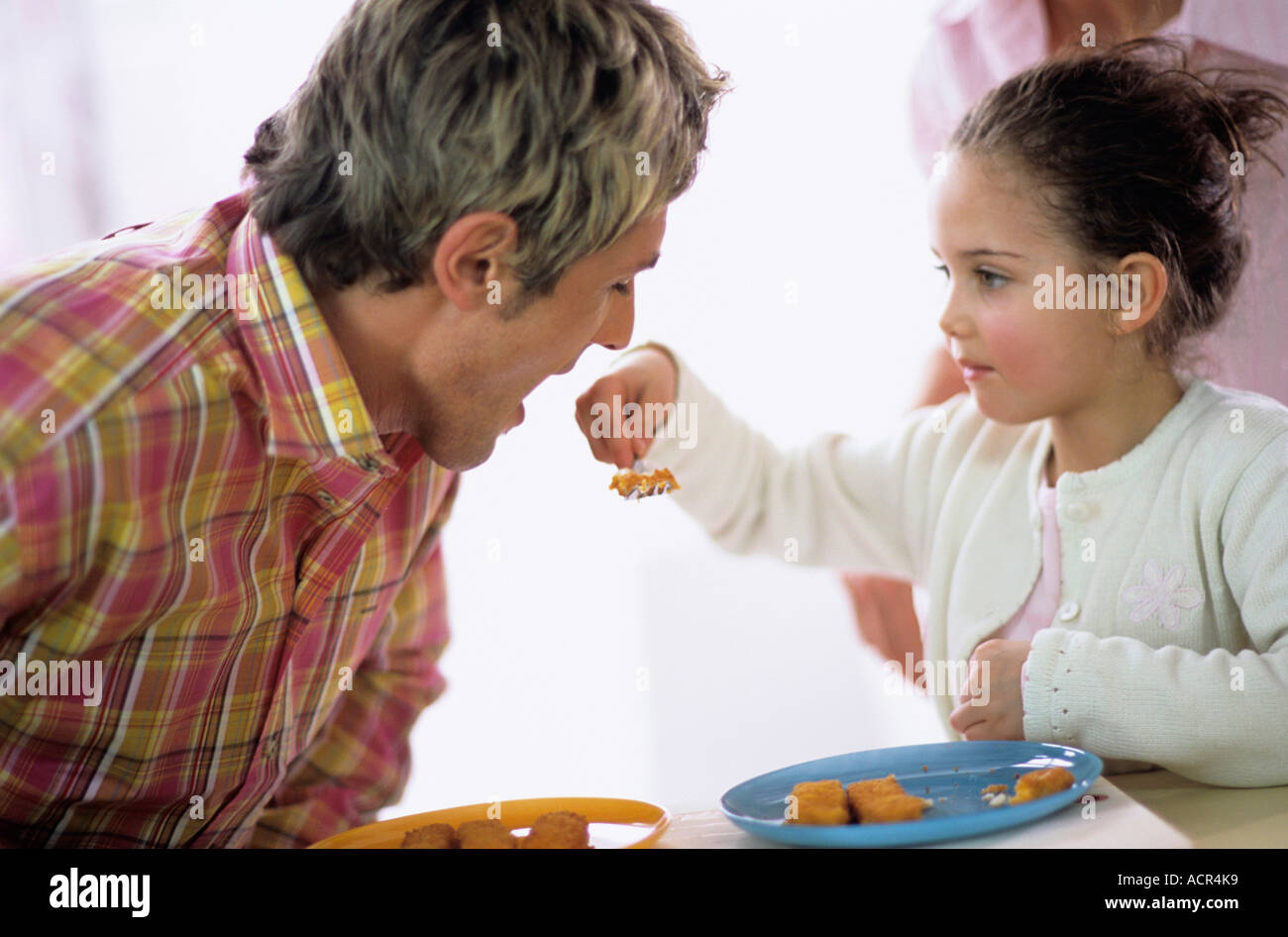 Alimentation fille père avec les bâtonnets de poisson Banque D'Images