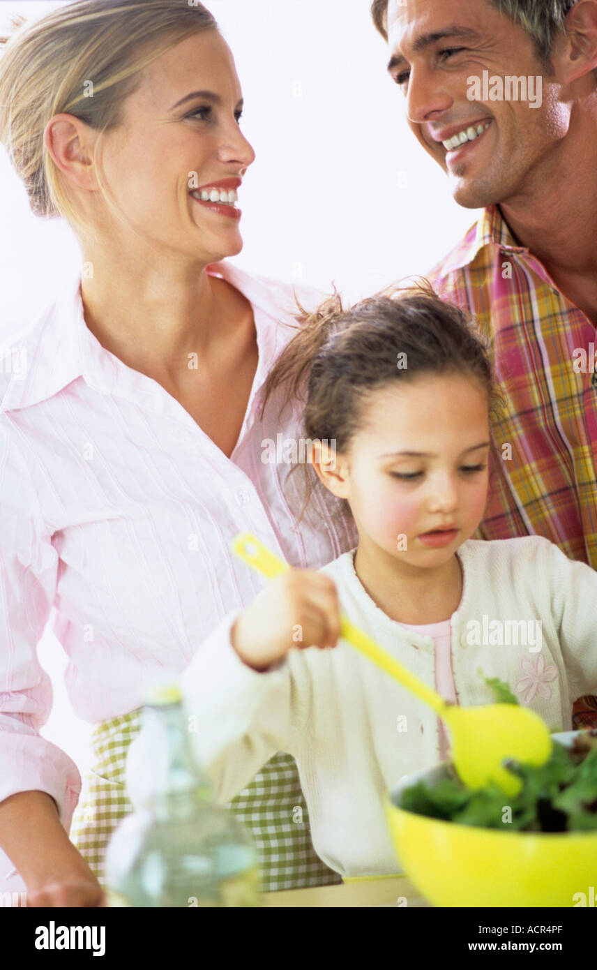 Les parents avec fille preparing salad Banque D'Images