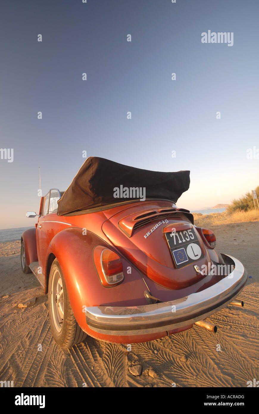 Un rouge-orange brillant Volkswagen Beetle convertible sur la plage. L'année 2007. Banque D'Images