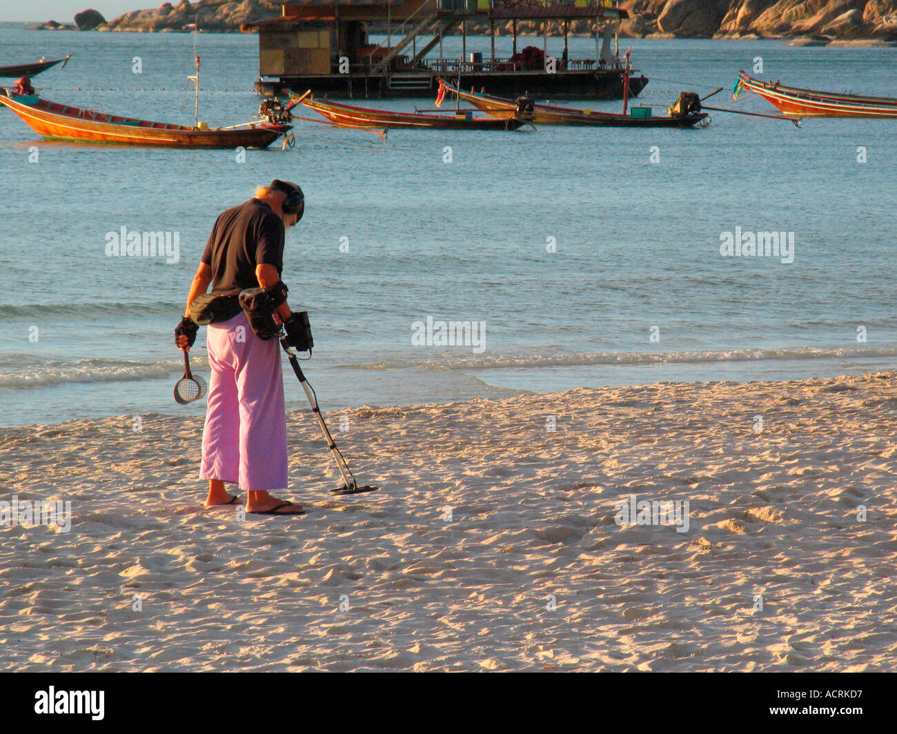 À l'aube de prospecteur avec détecteur de métal sur Sunset Beach Ko Pha Ngan island Thaïlande Banque D'Images