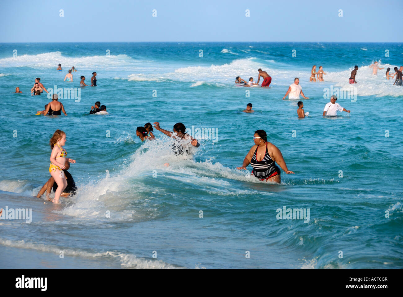 Les amateurs de plage à gué et jouant dans les vagues Pensacola Beach en Floride Banque D'Images
