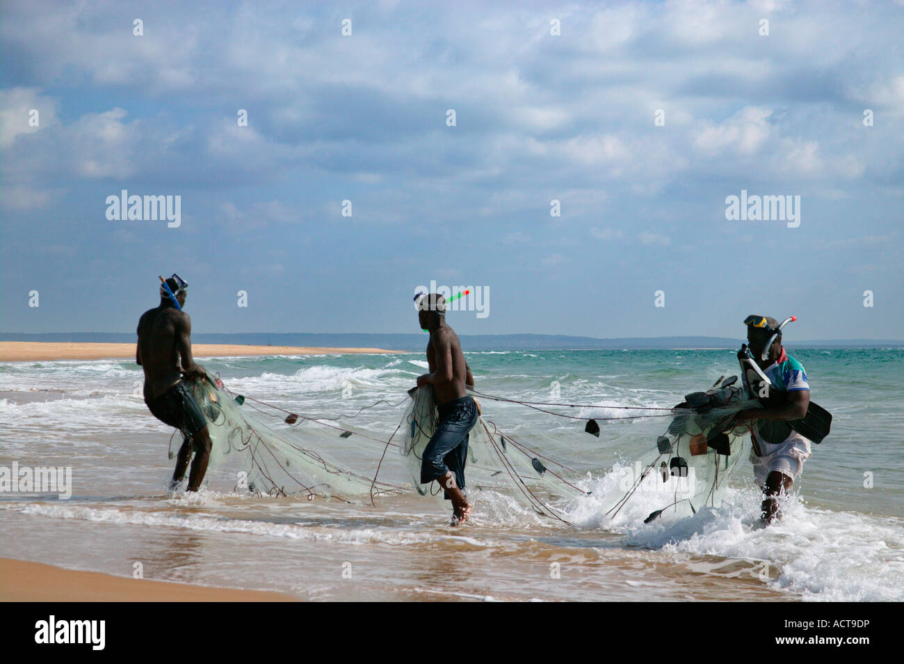 Les pêcheurs locaux en faisant glisser un filet de la mer sur la plage Barra la Province d'Inhambane au Mozambique Banque D'Images