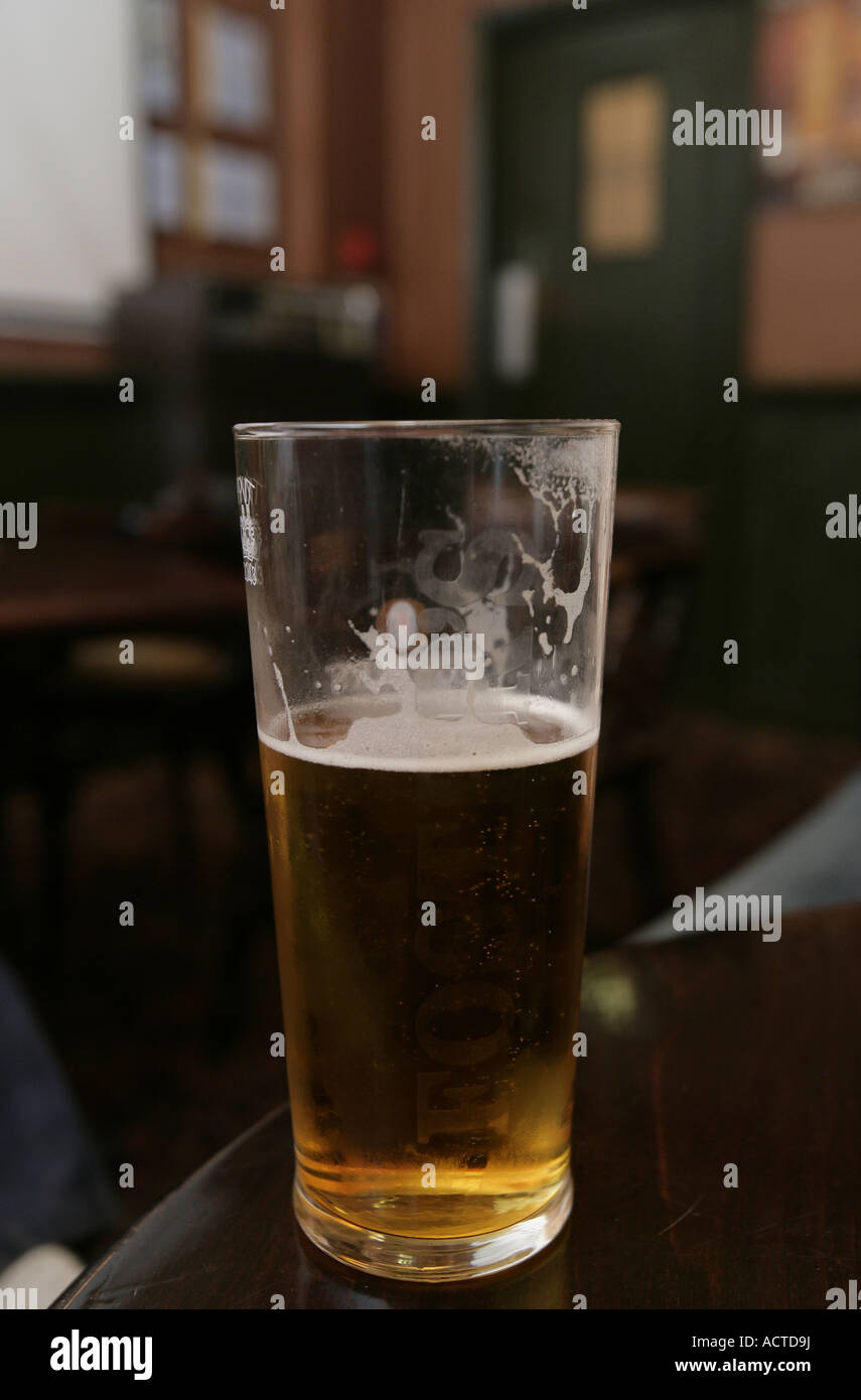 Une demi-pinte de bière sur une table dans un pub Banque D'Images