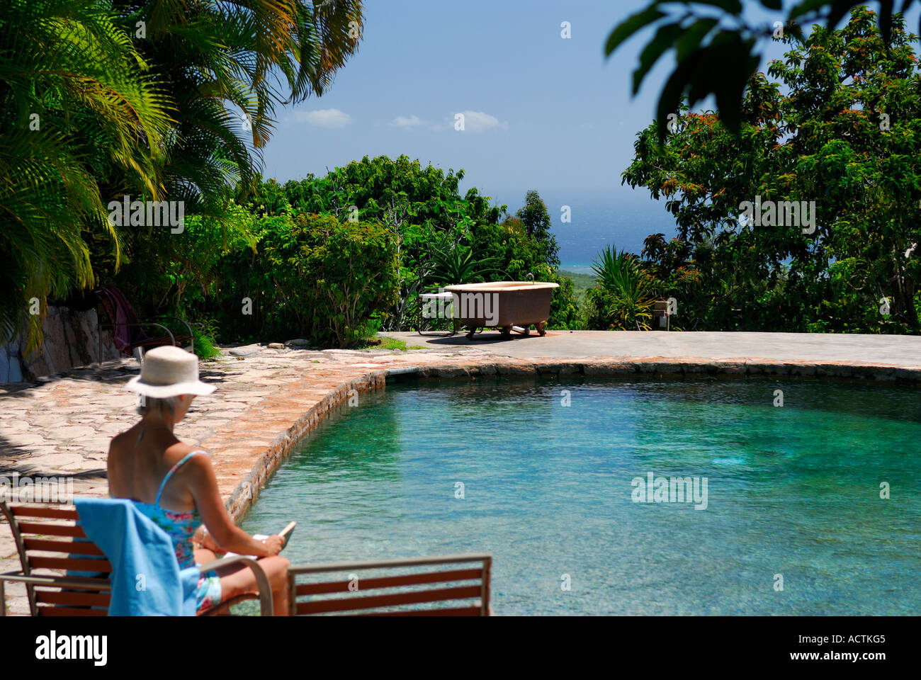 Femme lisant de la piscine sur Molokai Hawaii avec baignoire extérieure Banque D'Images