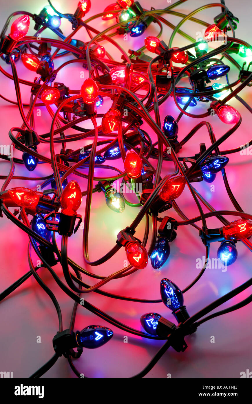 Fouillis de rouge et bleu emmêlés les lumières de Noël sur fond blanc Banque D'Images