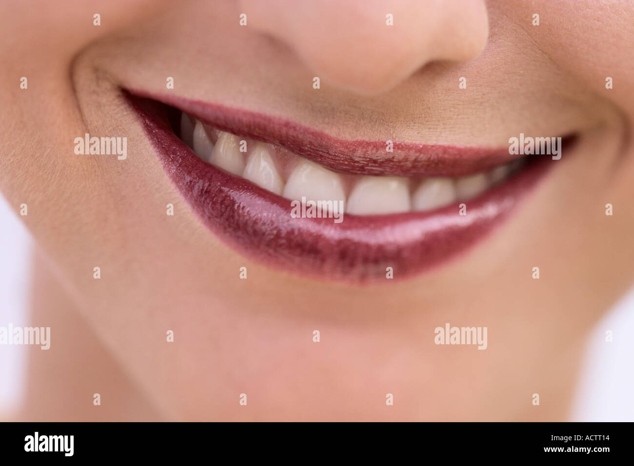 Bouche au sourire d'une femme avec des lèvres rouge claret Banque D'Images
