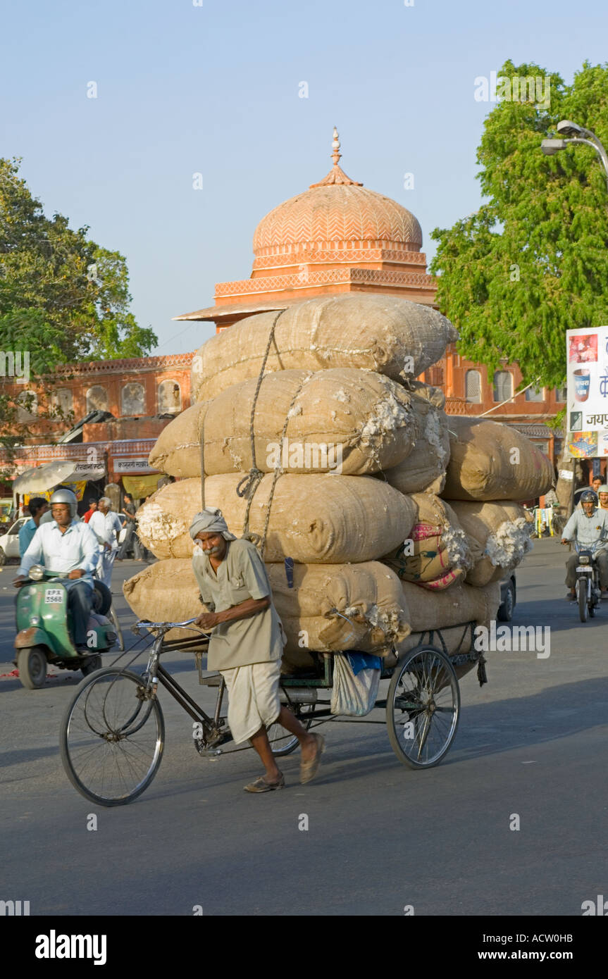 Un cycle rickshaw surchargé, poussé dans les rues de Jaipur. Banque D'Images