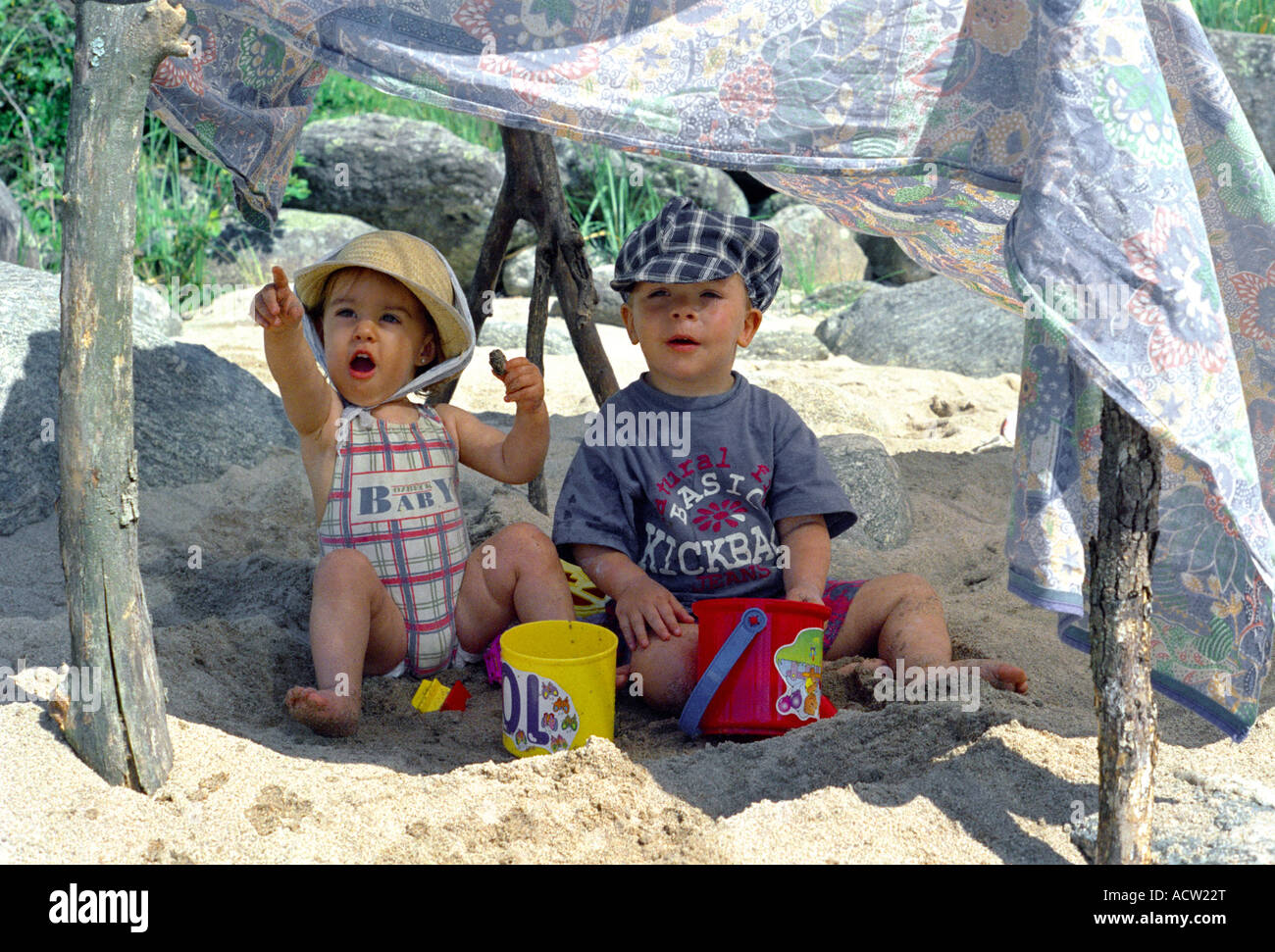 Deux enfants avec des chapeaux sous une tente improvisée sur une plage de la rivière Banque D'Images