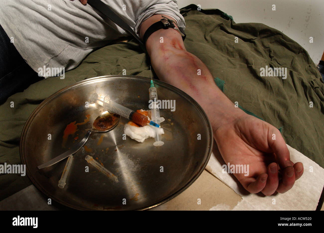 Un héroïnomane souffrant d'une overdose après une correction de la drogue à travers une aiguille hypodermique (posé par modèle) Banque D'Images