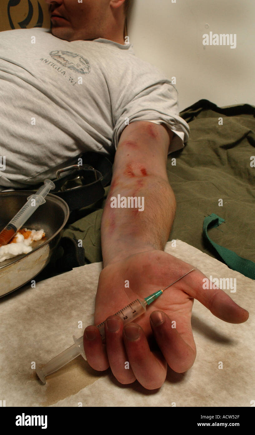 Un héroïnomane souffrant d'une overdose après une correction de la drogue à travers une aiguille hypodermique (posé par modèle) Banque D'Images