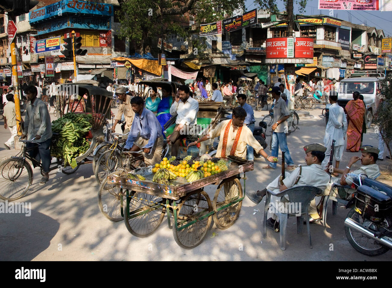 Vendeur de fruits avec des raisins à des policiers offrant panier Varanasi Bénarès Inde Banque D'Images