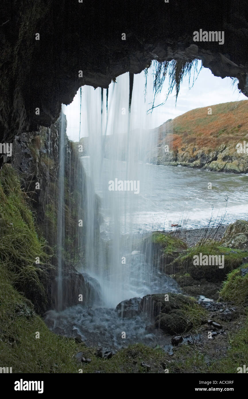 Derrière une cascade à partir de l'intérieur d'une grotte à Port Mora sur le sentier du littoral près de Portpatrick, Dumfries et Galloway, Écosse, Royaume-Uni Banque D'Images