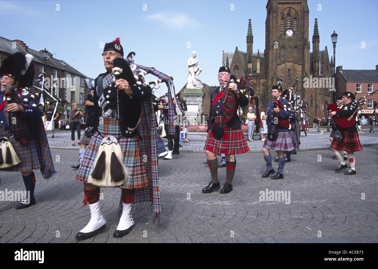 Le centre-ville de Dumfries Massed Pipes and Drums canadiennes marchant passé Robert Burns statue et l'église de Greyfriars Banque D'Images