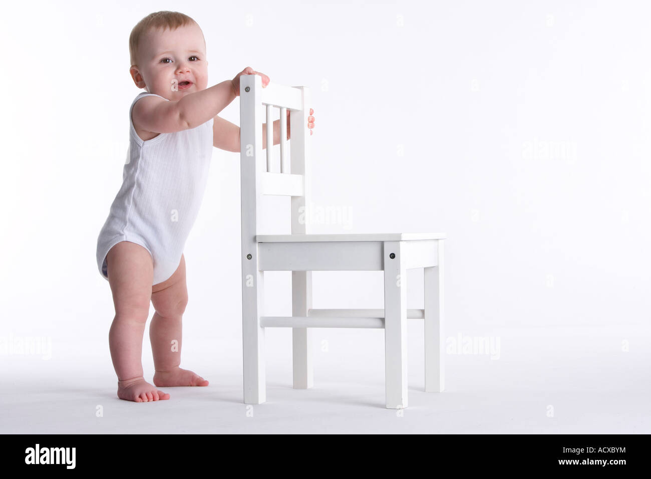 Bebe Garcon Debout Contre Une Petite Chaise Photo Stock Alamy