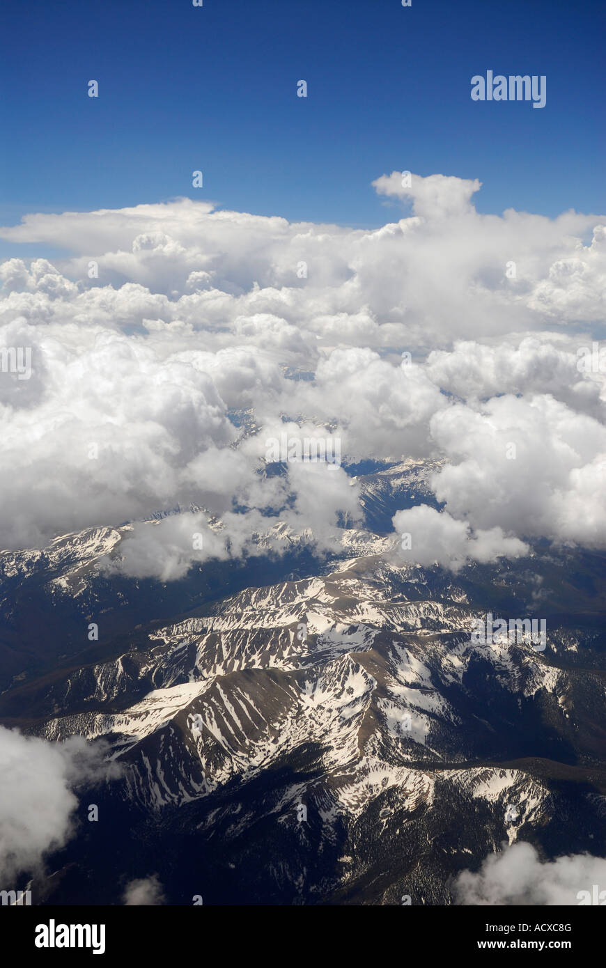 Photo aérienne des montagnes Rocheuses avec puffy nuages blancs et ciel bleu Banque D'Images