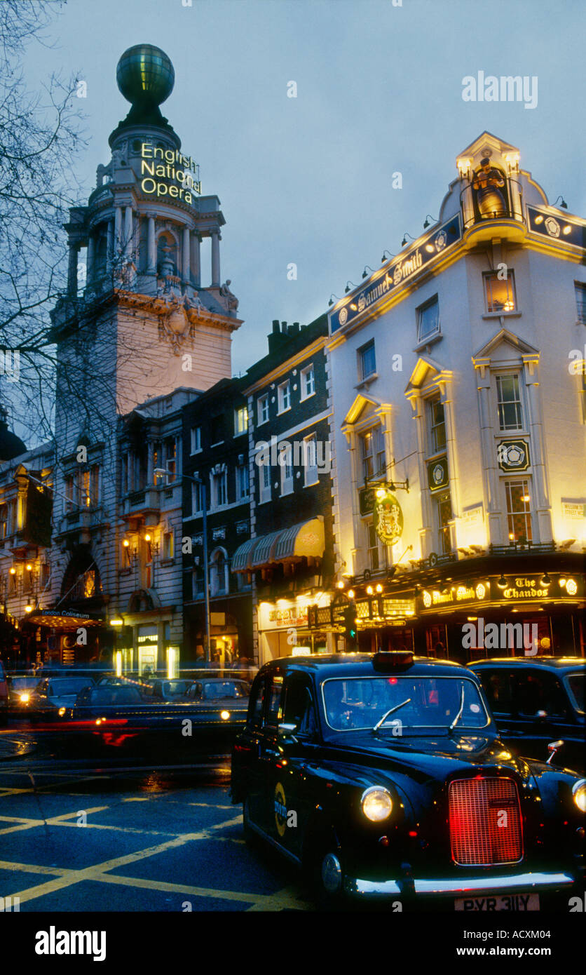 Vue de la nuit de la vie de la rue et allumé avec un Coliseum Theatre London, London taxi noir Banque D'Images