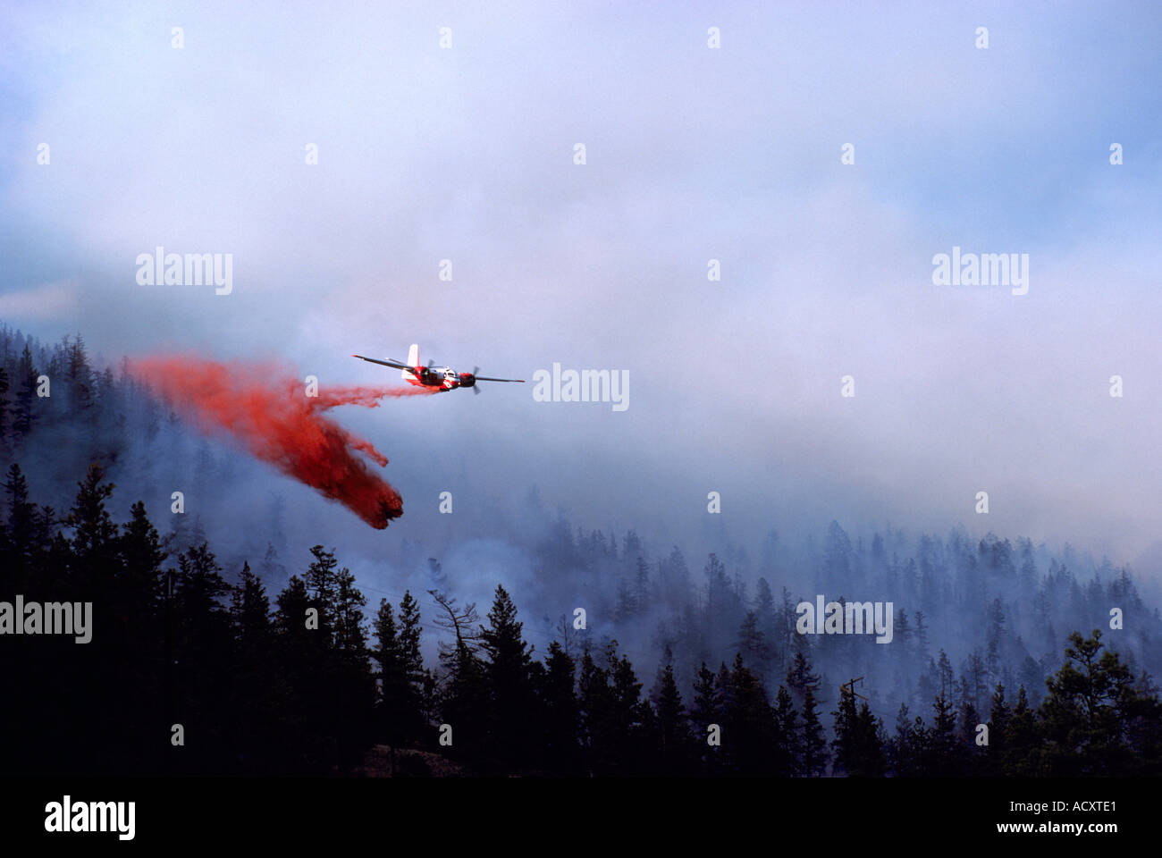 Un bombardier à eau tomber l'eau et au feu pendant la lutte contre l'incendie de forêt en Colombie-Britannique Canada Banque D'Images