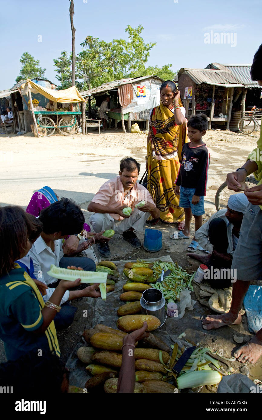 La population locale de manger des concombres. Marché. Lumbini. Le Népal Banque D'Images