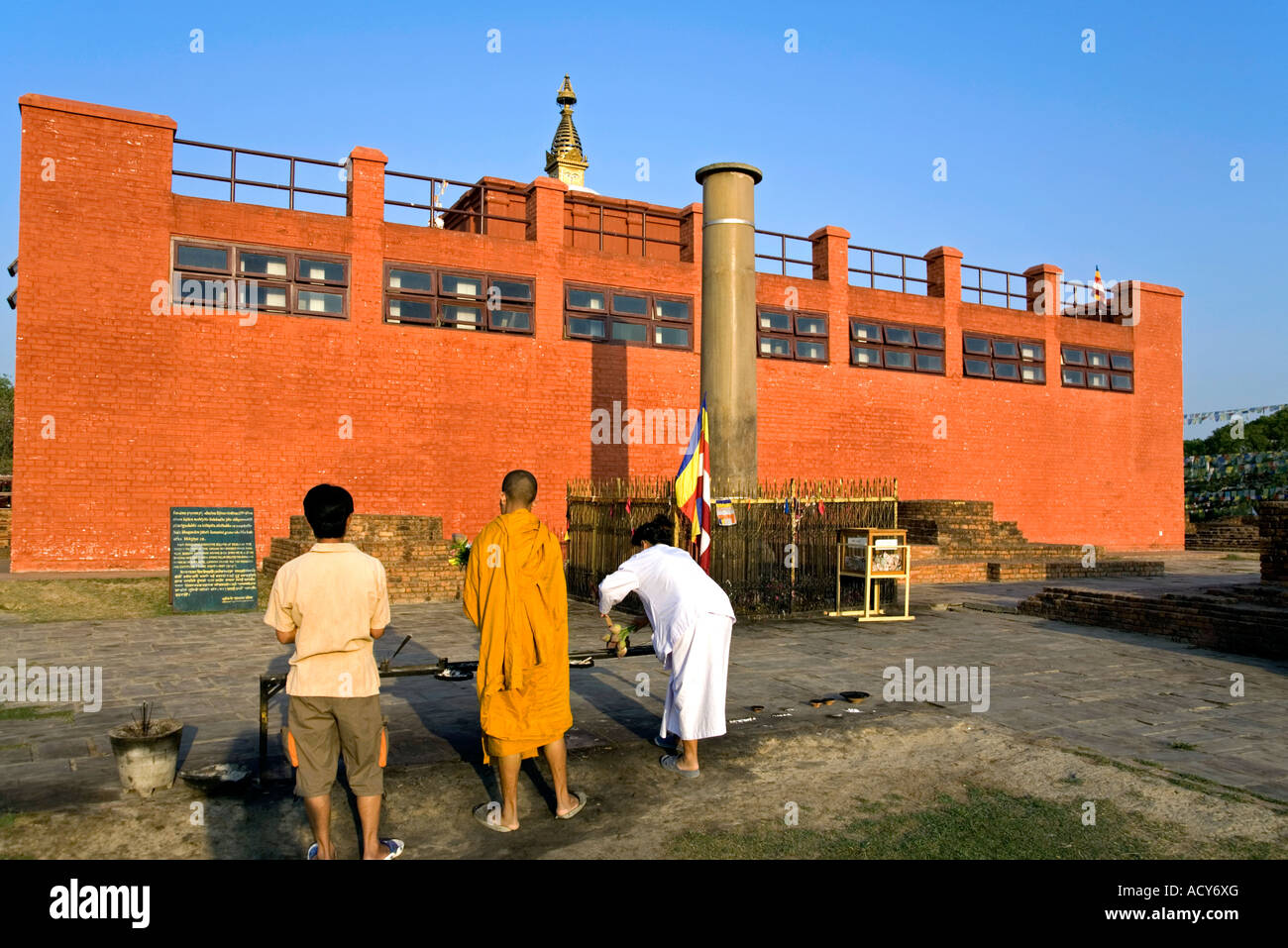 Pèlerins priant devant l'empereur Ashoka pilier.Lumbini.Lieu de naissance de Bouddha.Népal Banque D'Images
