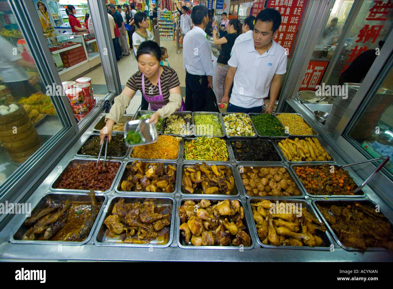 Femme servant de la nourriture dans un petit restaurant à l'intérieur de la gare de Hangzhou China Banque D'Images