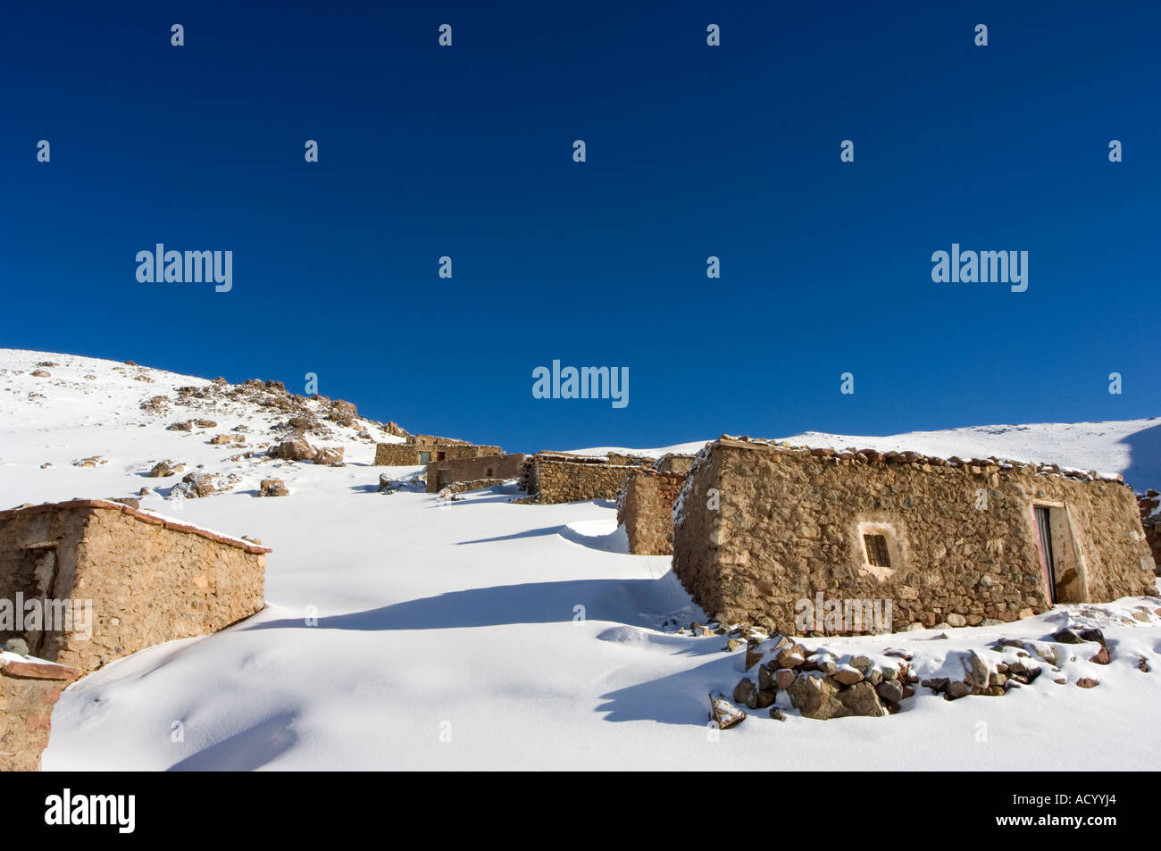 Maisons traditionnelles en pierre de la neige sur la montagne de ski de l'Oukaimeden Haut Atlas Maroc Afrique du Nord Banque D'Images