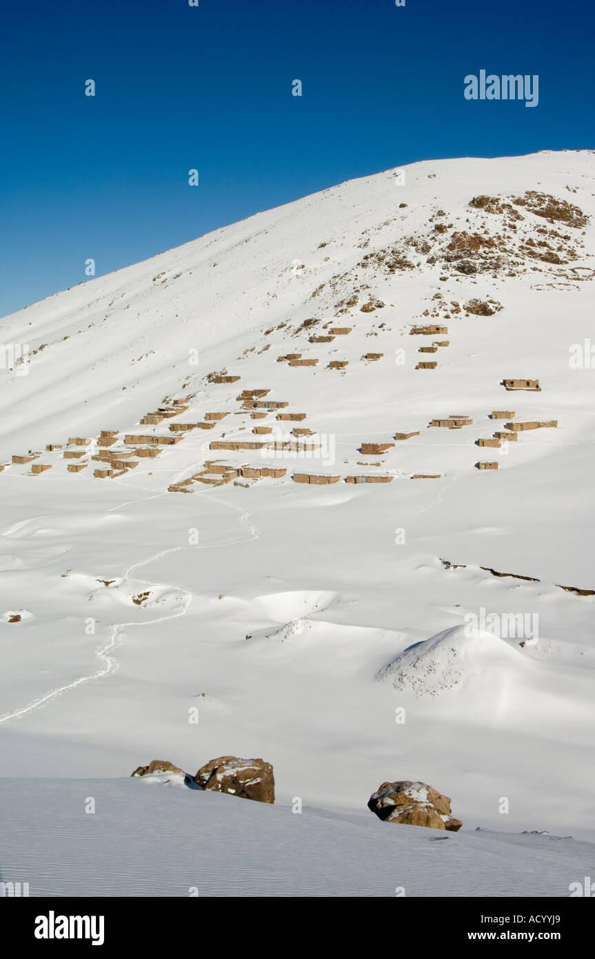 Maisons traditionnelles en pierre de la neige sur la montagne de ski de l'Oukaimeden Haut Atlas Maroc Afrique du Nord Banque D'Images