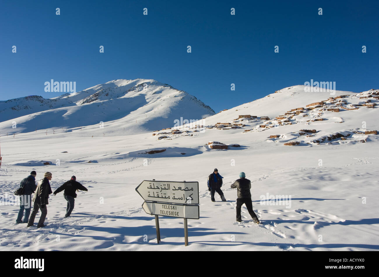 La population locale touristes profitant de la neige sur les montagnes de ski Station de ski Oukaimeden Haut Atlas Maroc Afrique du Nord Banque D'Images