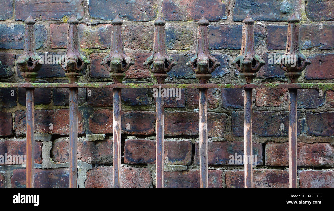 Détail de l'ancienne tige clôture de fer contre mur de briques. Banque D'Images