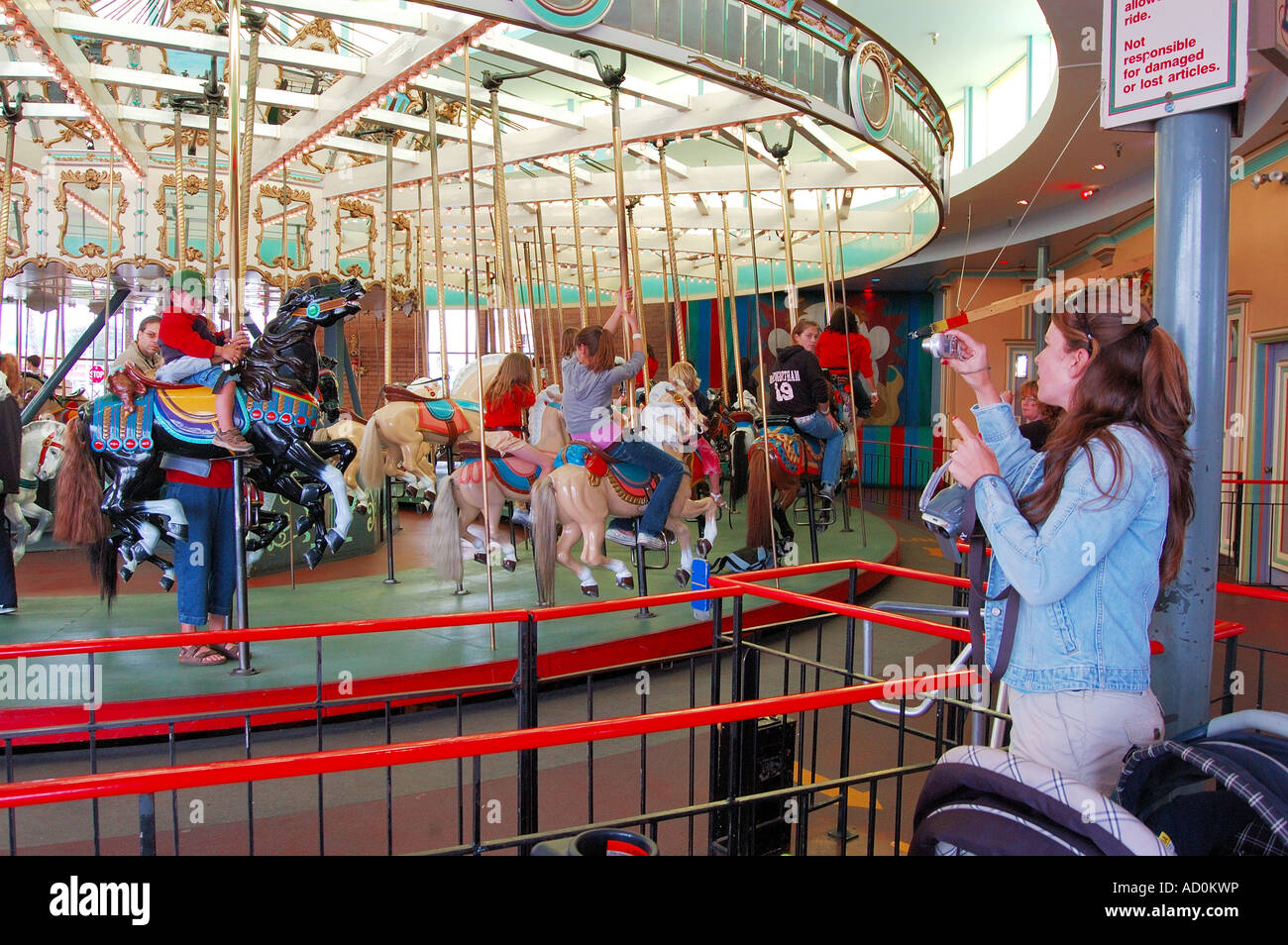 Merry go round manège construit en 1911 par Charles I D Looff au Boardwalk de Santa Cruz Ca - maman et grand-mère fils photographie Banque D'Images