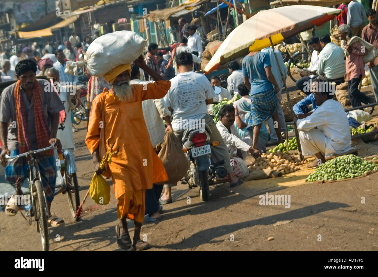 Grand angle horizontal d'un Indien typique occupé scènederue avec un homme portant un gros paquet sur sa tête, marchant le long de la route Banque D'Images