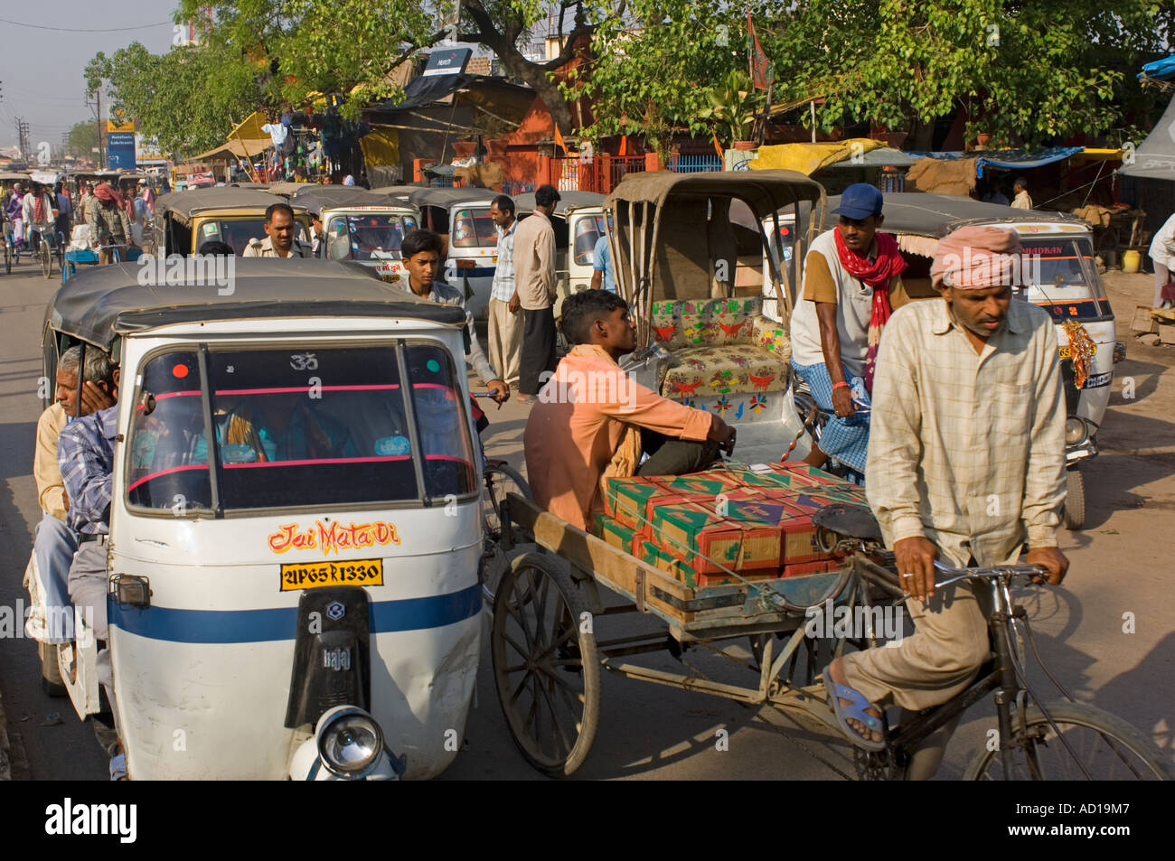 Une scène de rue chaotique typique à Varanasi avec randonnée et auto rickshaws (Tuk Tuks) sur les rues animées. Banque D'Images