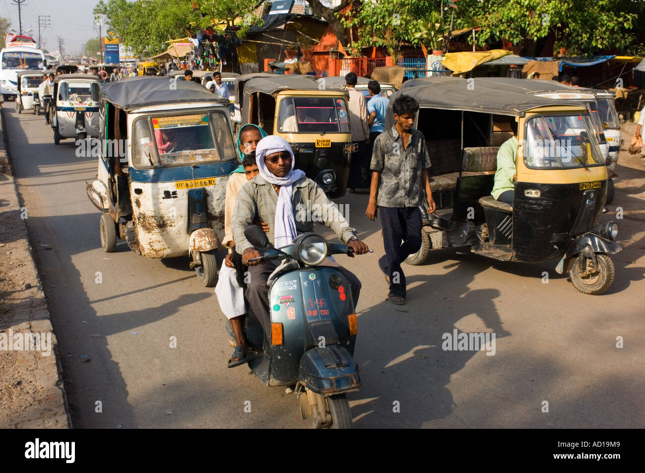 Une scène de rue chaotique typique à Varanasi avec auto-pousse (Tuk Tuks), des scooters et des gens sur les rues animées. Banque D'Images