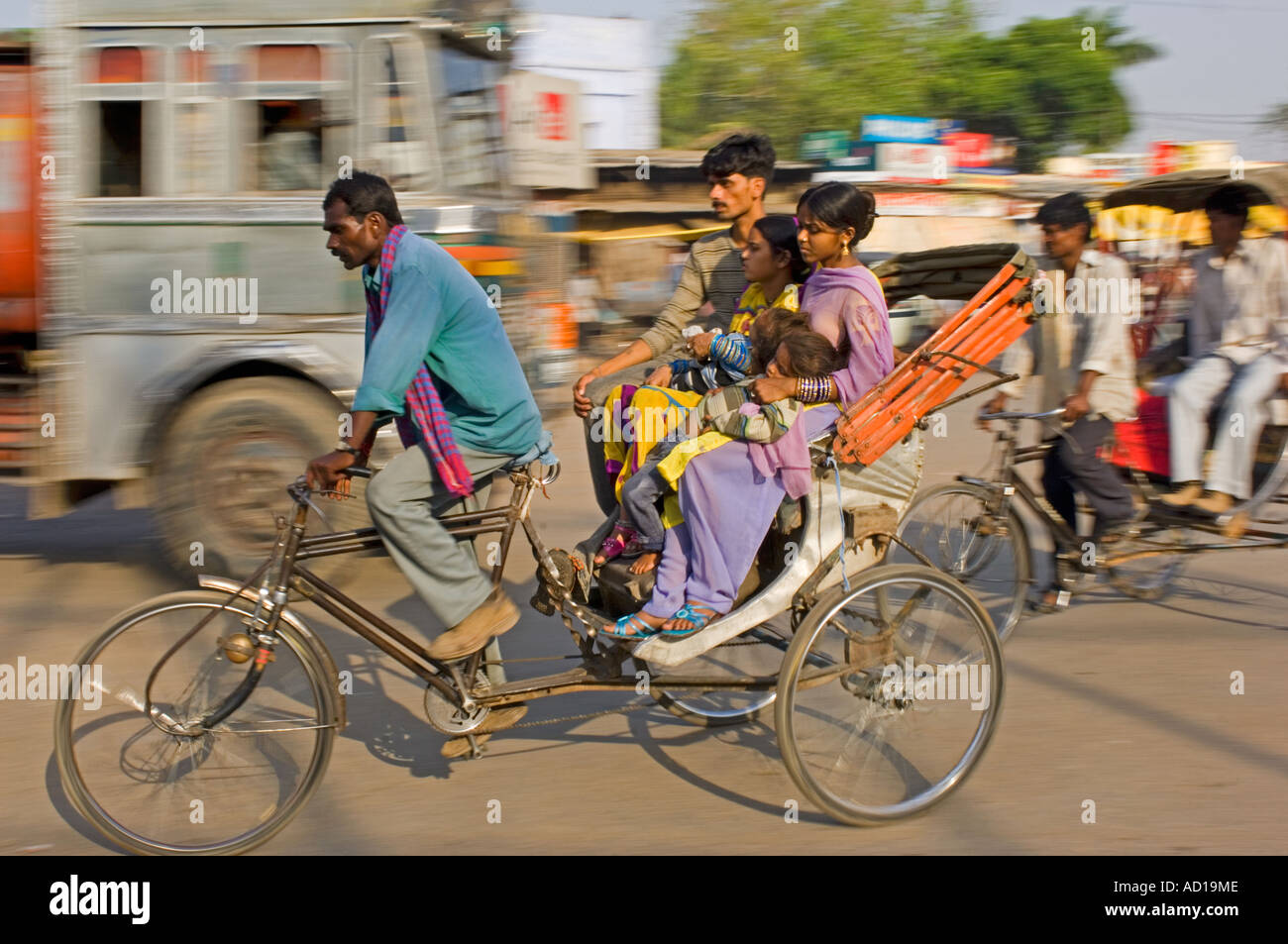 Une scène de rue à Varanasi avec une famille sur un cycle rickshaw. Vitesse d'obturation lente et le panoramique de flou. Banque D'Images