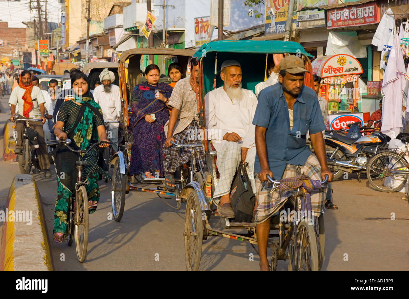 Une vue en perspective d'une rue animée à Varanasi avec des gens sur des vélos et vélos-pousse. Banque D'Images