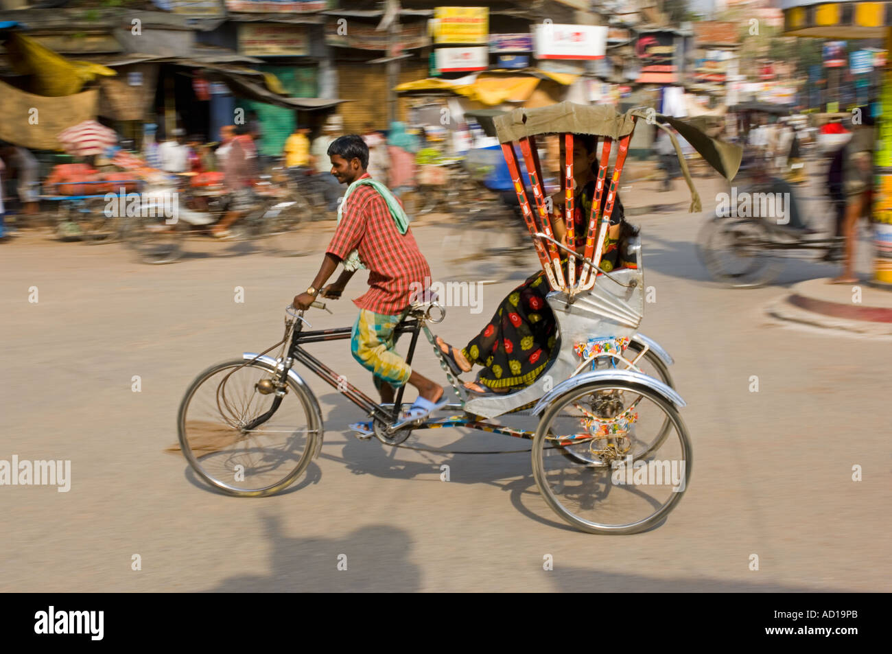 Une femme indienne sur un cycle rickshaw à Varanasi. Vitesse d'obturation lente et le panoramique de flou. Banque D'Images
