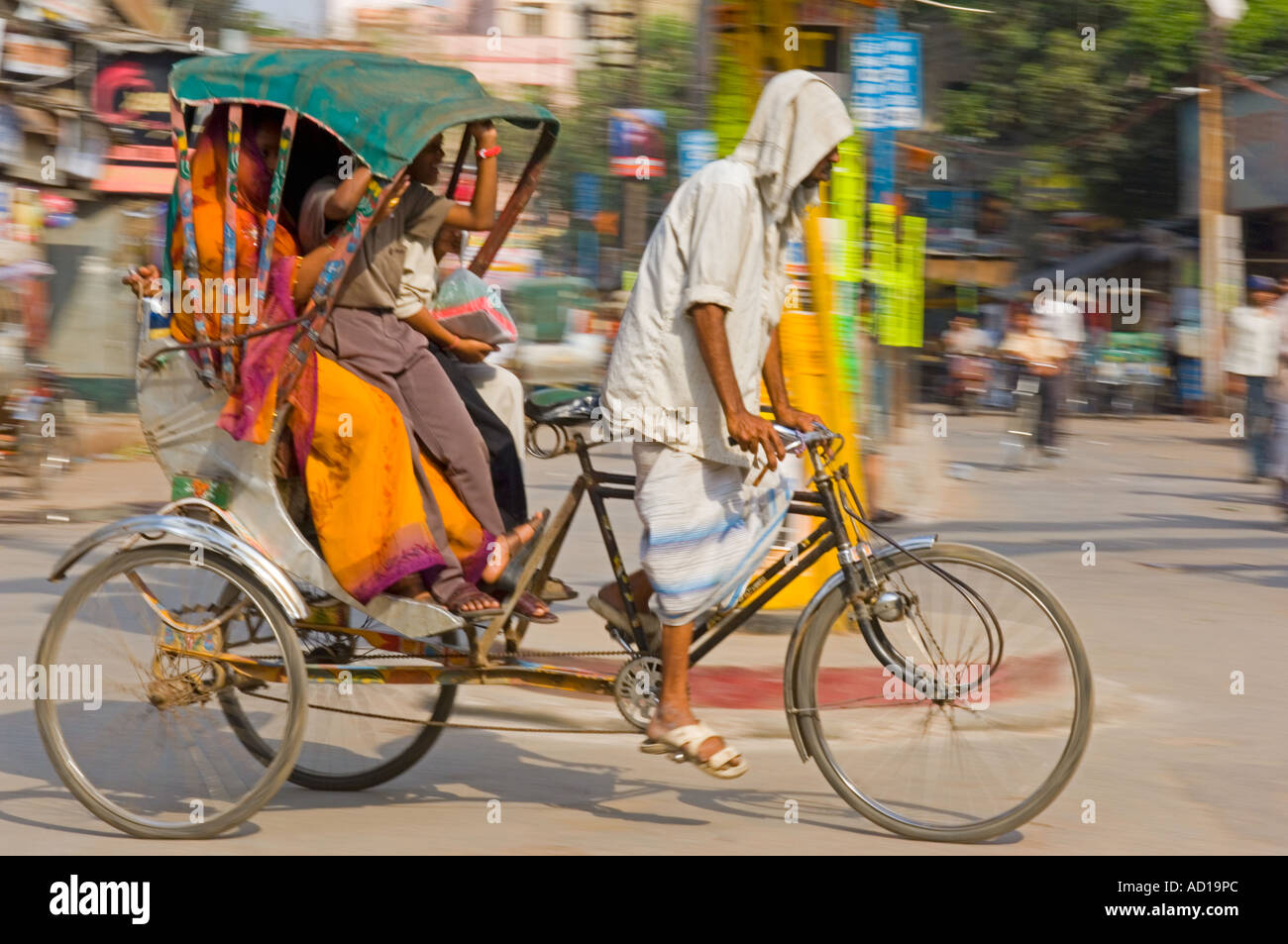 Une famille indienne sur un cycle rickshaw à Varanasi. Vitesse d'obturation lente et le panoramique de flou. Banque D'Images