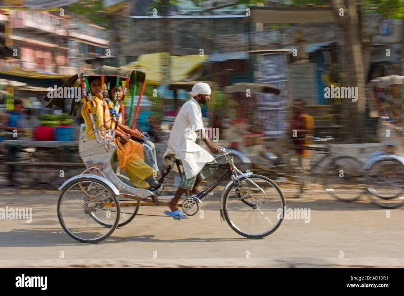 Deux femmes indiennes sur un cycle rickshaw à Varanasi. Vitesse d'obturation lente et le panoramique de flou. Banque D'Images