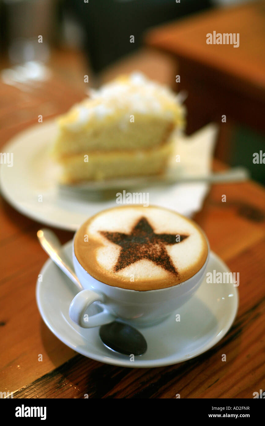Un Cappucino avec café chocolat décoratif sur star top hummingbird cake en arrière-plan Banque D'Images