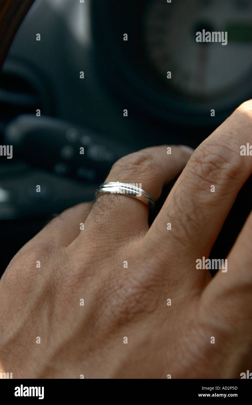 La main avec une bague de mariage sur un volant Photo Stock - Alamy