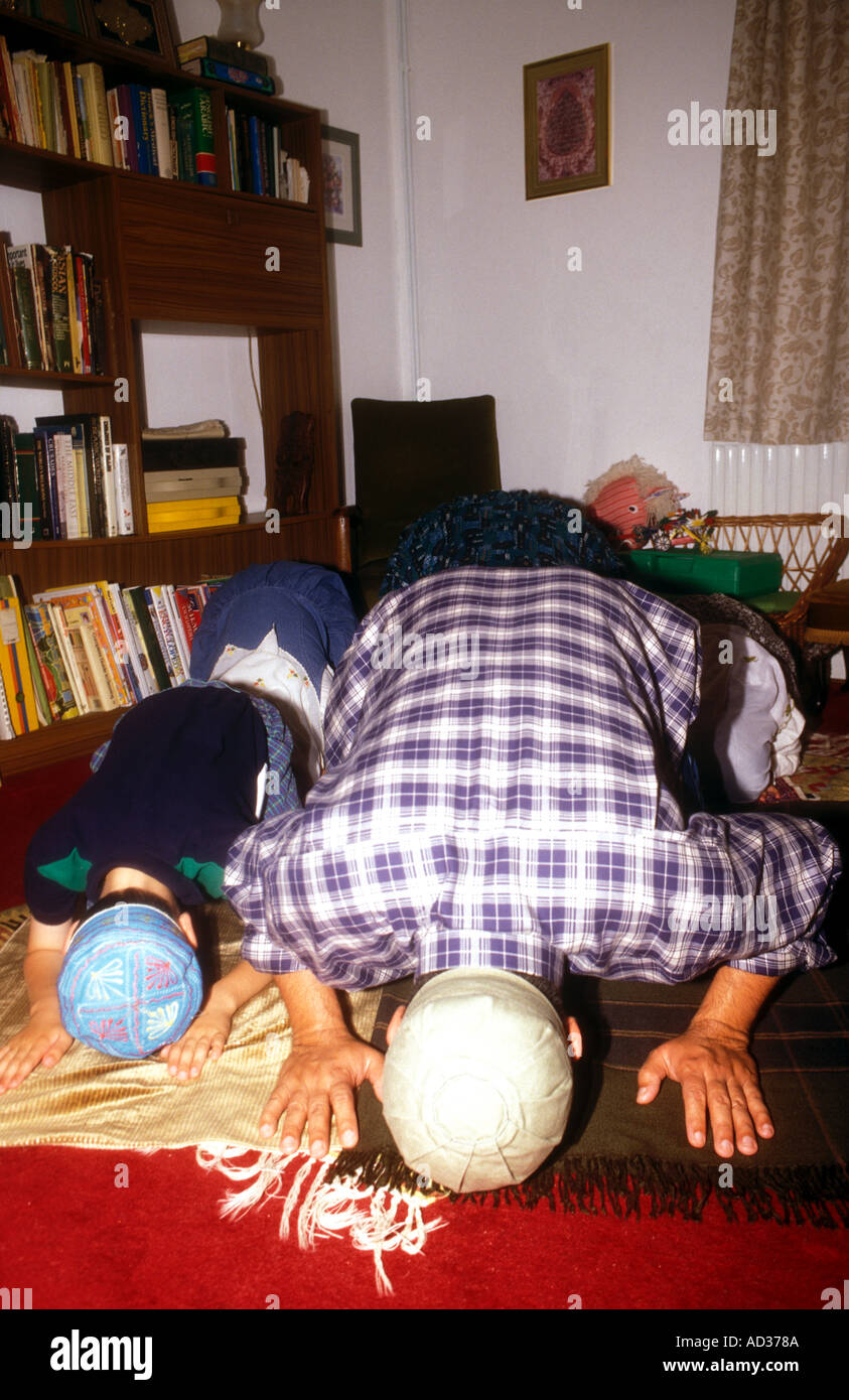 La prière islamique de la famille dans leur maison dans le Surrey en Angleterre Banque D'Images