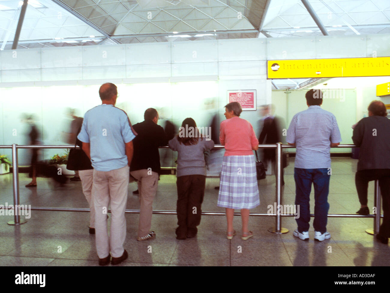 Les gens qui attendent pour recueillir et rencontrez les passagers du terminal des arrivées de l'aéroport de Stansted, Royaume-Uni Banque D'Images