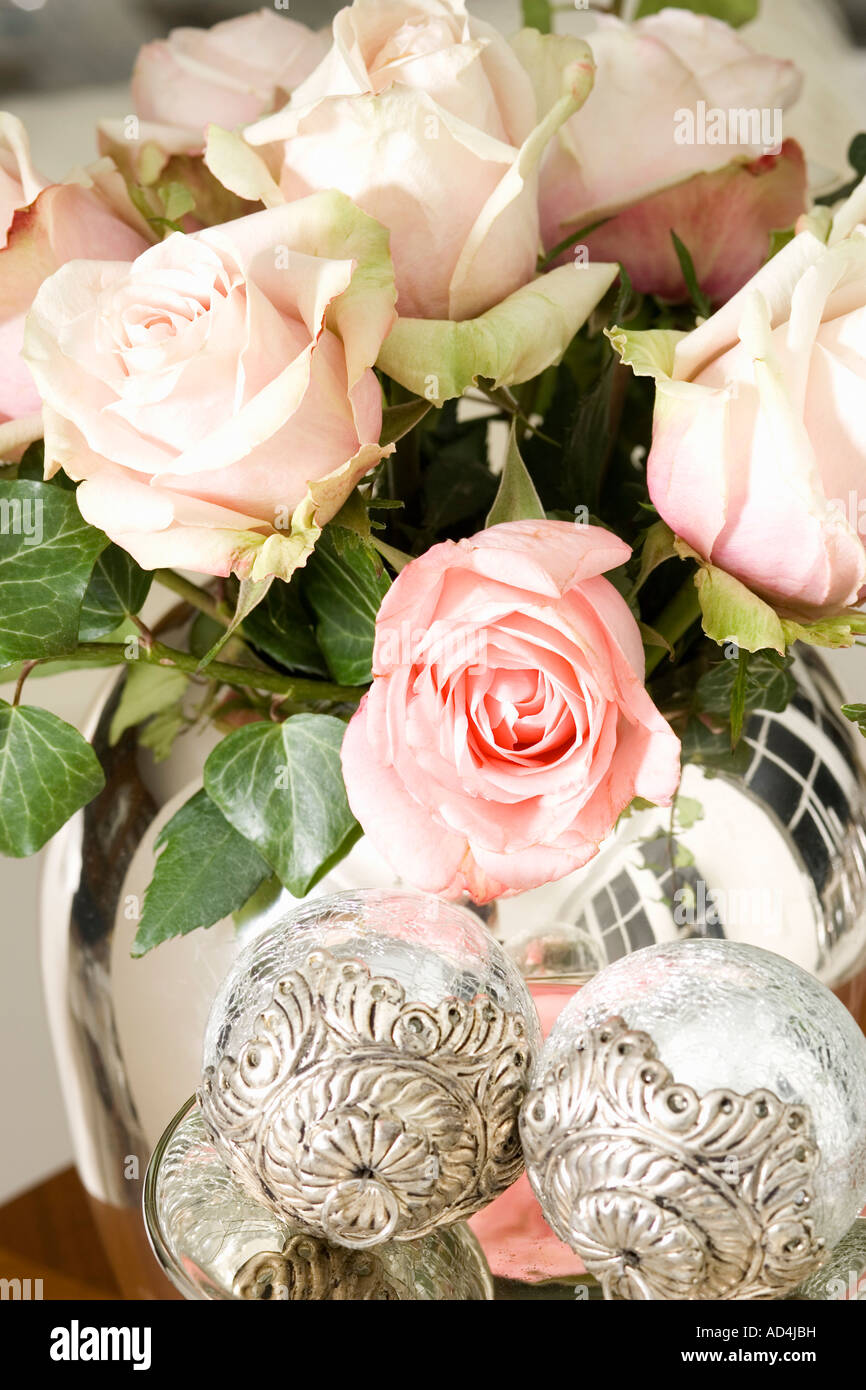 Un bouquet de roses rose pâle dans un vase d'argent Banque D'Images